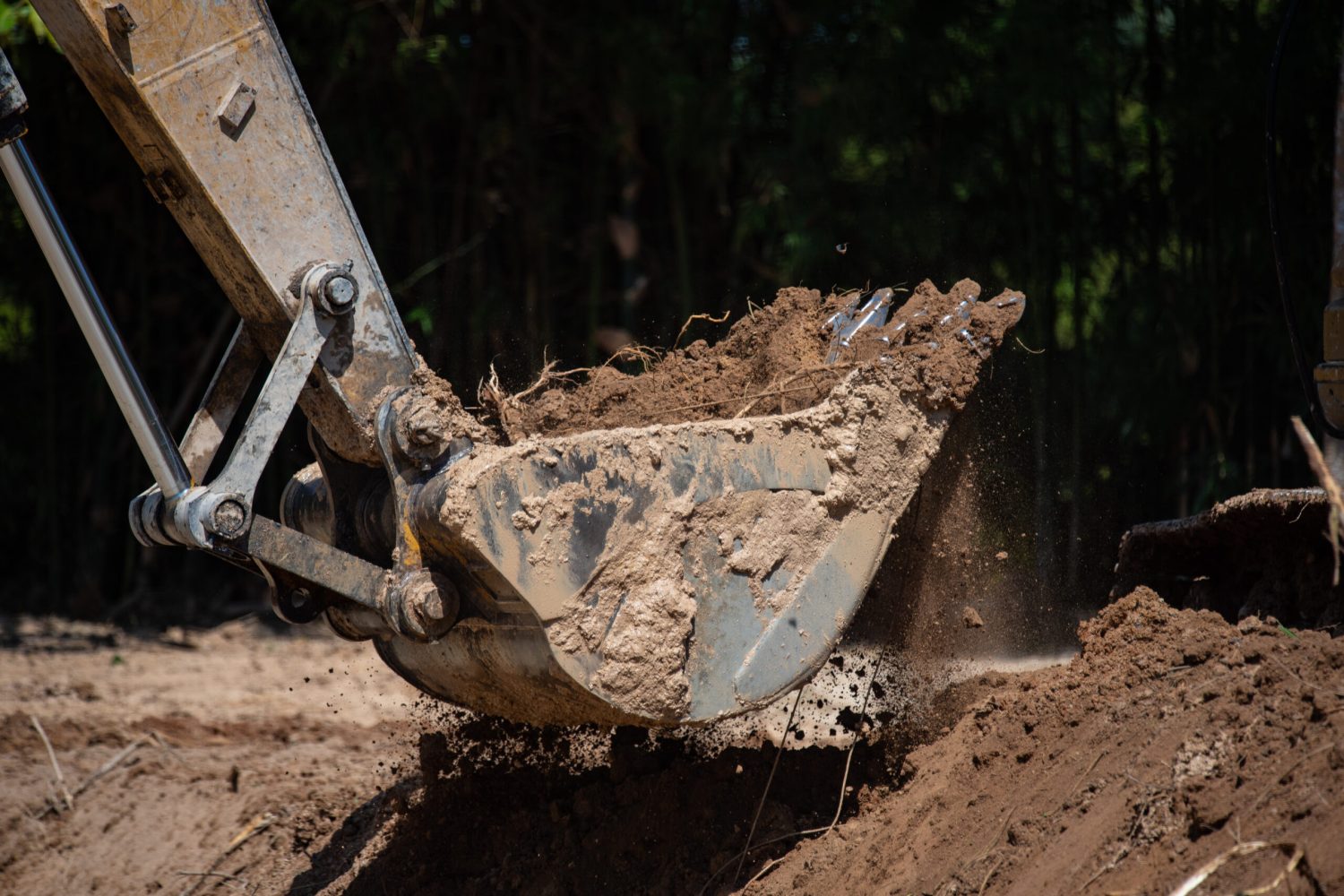 Closeup of bulldozer machine digging the ground and removing sand for excavation purpose at construction and repair site for underground work